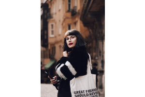 a person wearing a promotional tote bag with a quote on it